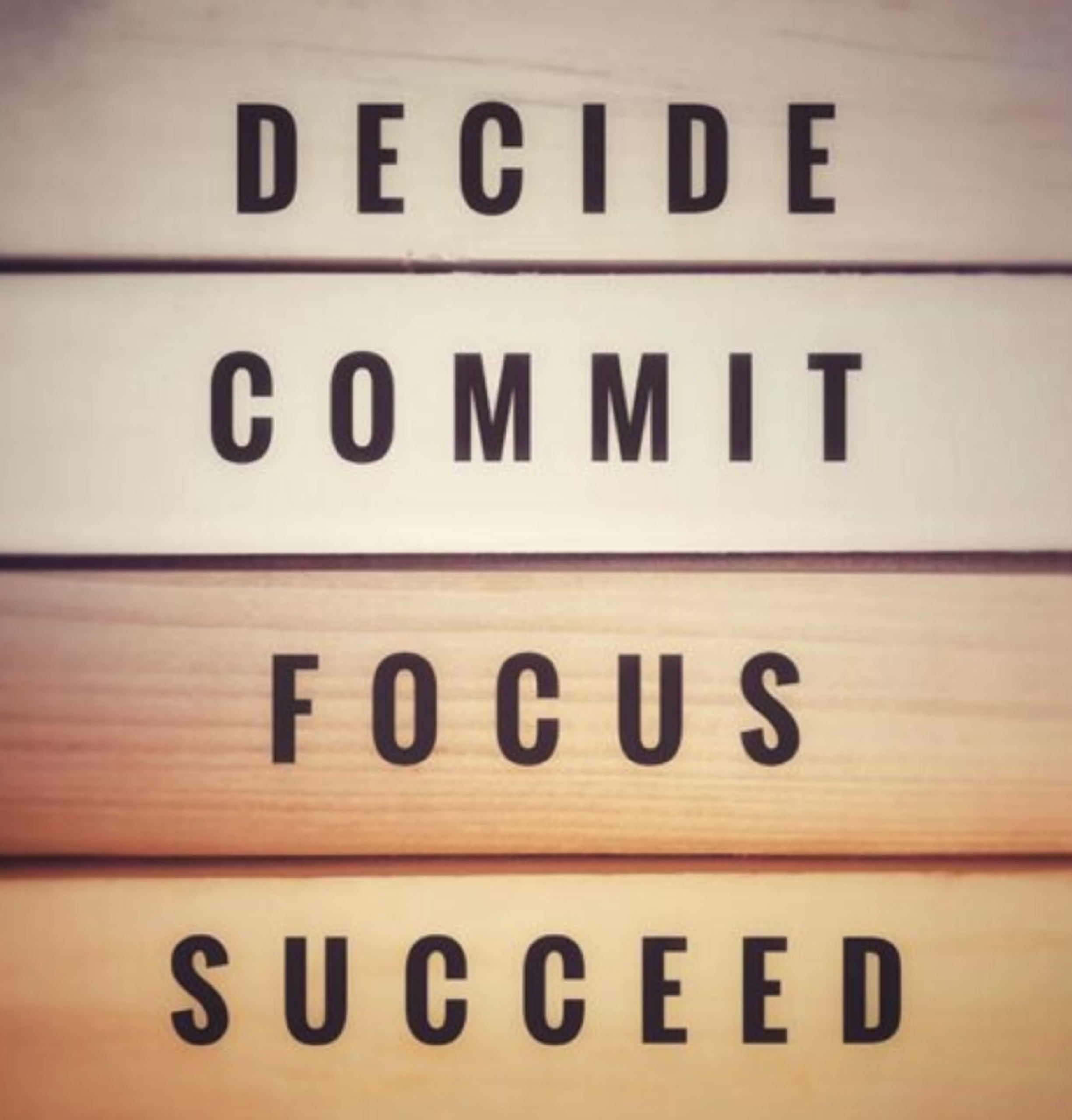 Aanpak LeadInspire: houten letters met de woorden Decide, Commit, Focus en Succeed als symbool voor daadkrachtig leiderschap