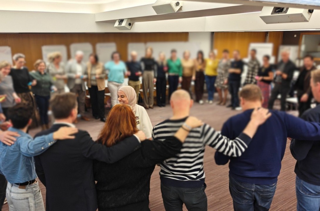 Teamcoaching sessie waarbij een groep samen staat in een cirkel — Lead & Inspire