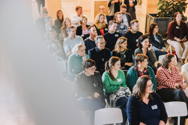 Aanpak Lead & Inspire voor organisaties: groep professionals luistert aandachtig tijdens een leiderschapssessie